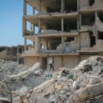 A man walks through rubble in Idlib, Syria, illustrating destruction from conflict.