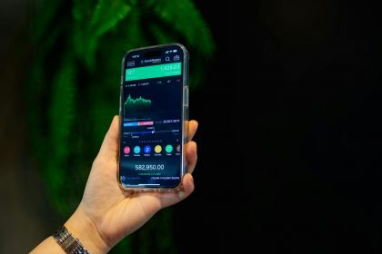 Close-up of a smartphone displaying a stock trading app with market data on-screen.