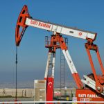 Bati Raman oil pump jack in Batman, Turkey. Industrial landscape with city view.